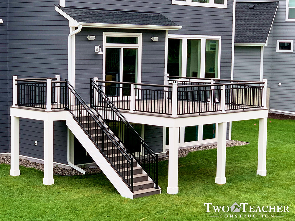 A maintenance-free composite deck with black and white aluminum railing overlooking a suburban backyard, built in Excelsior, MN