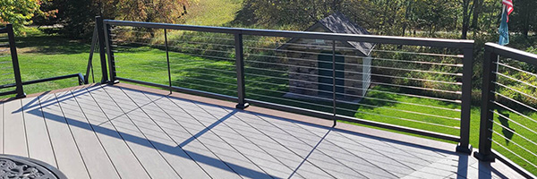 A deck with a cable railing style from Two Teacher Construction