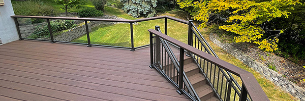 A deck with a glass railing style from Two Teacher Construction